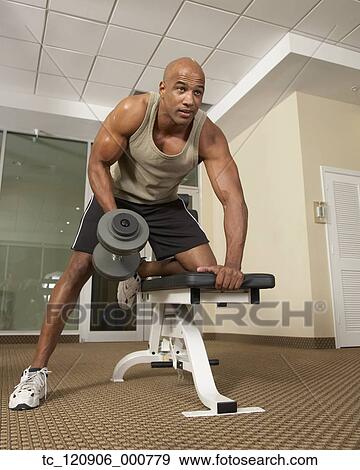 Stock Photo - Mixed Race man lifting weights. Fotosearch