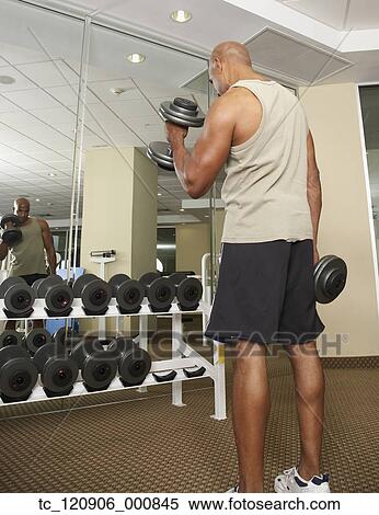 Stock Photography - Mixed Race man lifting weights. Fotosearch