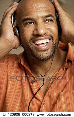 Mixed Race man listening to headphones View Large Photo Image Stock Image - Mixed Race man listening to headphones. Fotosearch