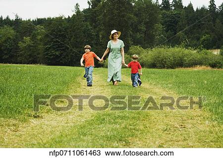 Mother and sons walking in field View Large Photo Image Stock Image - Mother and sons walking in field. Fotosearch