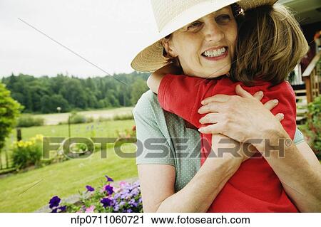 Stock Image - Mother hugging child outdoors. Fotosearch