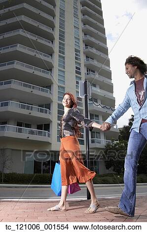 Picture - Multi-ethnic couple holding hands. Fotosearch