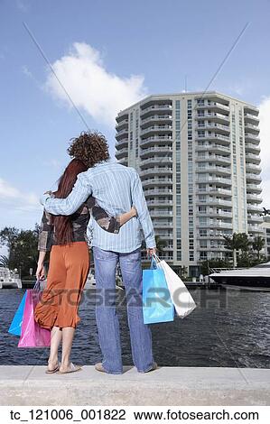 Multi-ethnic couple holding shopping bags View Large Photo Image Stock Image - Multi-ethnic couple holding shopping bags. Fotosearch