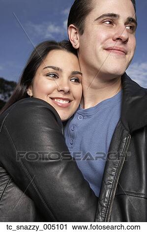 Stock Image - Multi-ethnic couple hugging outdoors. Fotosearch