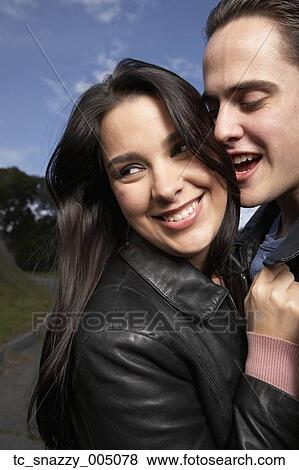 Stock Photo - Multi-ethnic couple hugging outdoors. Fotosearch