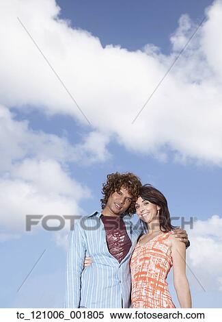 Stock Photography - Multi-ethnic couple hugging outdoors. Fotosearch