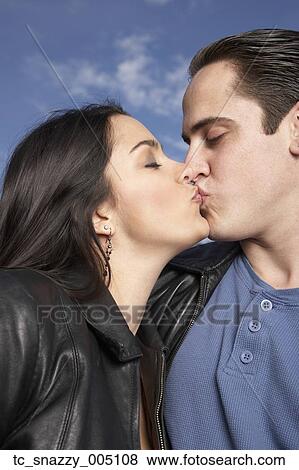 Stock Photo - Multi-ethnic couple kissing outdoors. Fotosearch