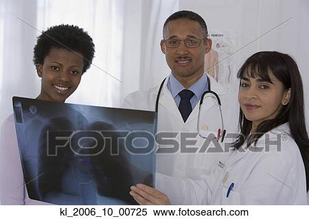 Stock Photography - Multi-ethnic doctors and patient looking at x-ray. Fotosearch