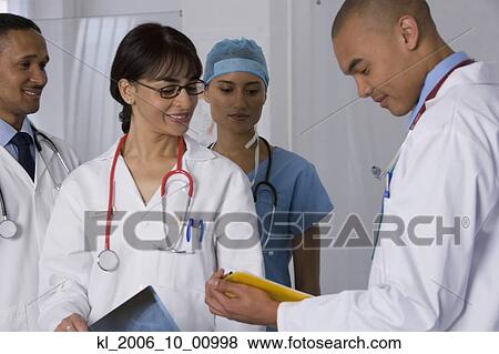 Stock Photo - Multi-ethnic doctors discussing chart. Fotosearch