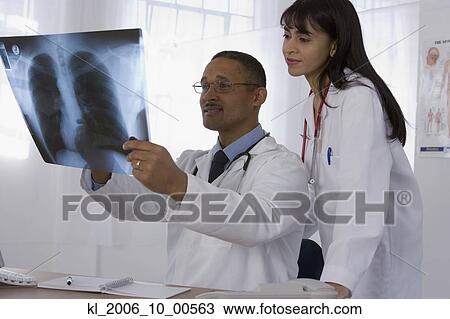 Stock Image - Multi-ethnic doctors looking at x-ray. Fotosearch