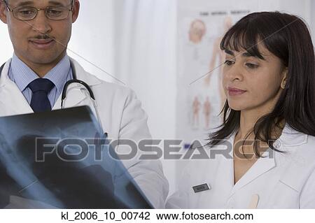 Stock Image - Multi-ethnic doctors looking at x-ray. Fotosearch