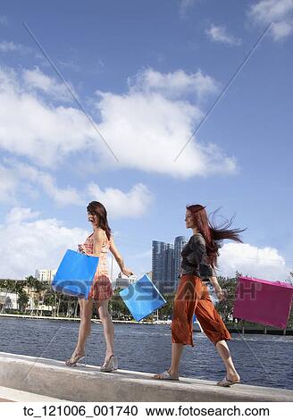 Multi-ethnic friends carrying shopping bags View Large Photo Image Stock Image - Multi-ethnic friends carrying shopping bags. Fotosearch