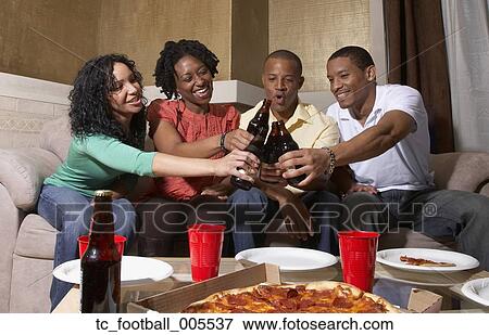 Stock Photo - Multi-ethnic friends having pizza party. Fotosearch