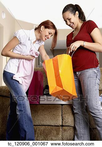 Multi-ethnic friends looking in shopping bags View Large Photo Image Stock Photo - Multi-ethnic friends looking in shopping bags. Fotosearch