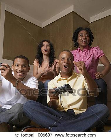 Multi-ethnic friends playing video games View Large Photo Image Stock Photo - Multi-ethnic friends playing video games. Fotosearch
