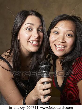 Multi-ethnic friends singing with microphone View Large Photo Image Stock Image - Multi-ethnic friends singing with microphone. Fotosearch
