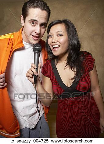 Stock Photography - Multi-ethnic friends singing with microphone. Fotosearch