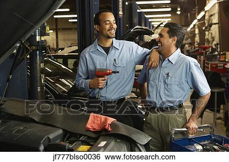 Stock Photograph - Multi-ethnic male auto mechanics in shop. Fotosearch