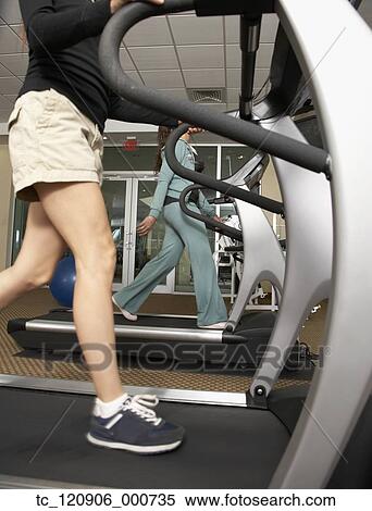 Stock Photography - Multi-ethnic women walking on treadmills. Fotosearch
