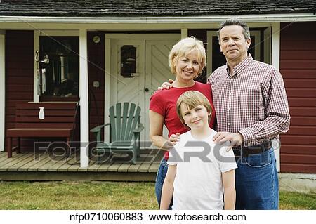 Stock Image - Portrait of family in front of house. Fotosearch