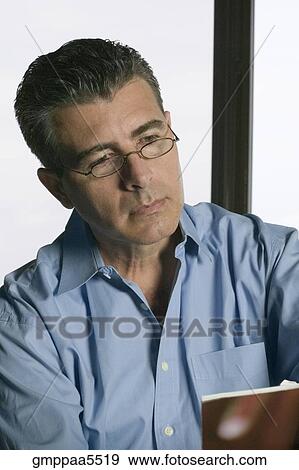 Studio shot of Hispanic middle-aged man reading View Large Photo Image Stock Photo - Studio shot of Hispanic middle-aged man reading. Fotosearch
