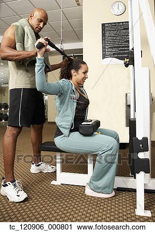 Trainer working with woman in health club View Large Photo Image Stock Image - Trainer working with woman in health club. Fotosearch