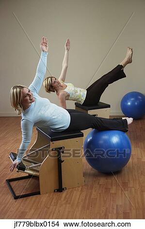 Two woman exercising on equipment View Large Photo Image Picture - Two woman exercising on equipment. Fotosearch
