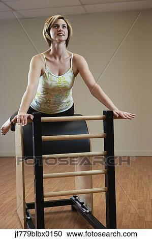 Woman exercising on equipment View Large Photo Image Stock Image - Woman exercising on equipment. Fotosearch