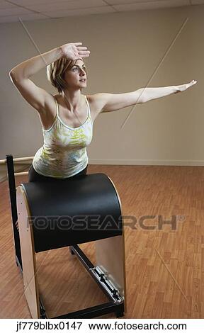 Woman exercising on equipment View Large Photo Image Stock Photo - Woman exercising on equipment. Fotosearch