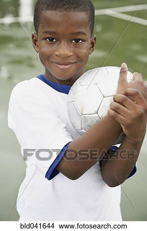 Picture - African American boy holding soccer ball. Fotosearch