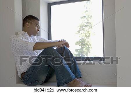 Stock Photography - African man sitting in window. Fotosearch