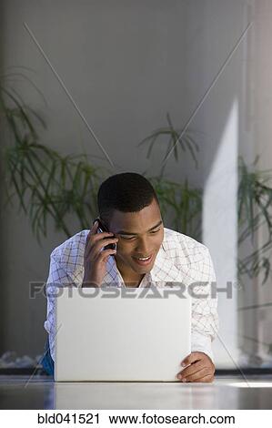 Stock Image - African man talking on cell phone. Fotosearch