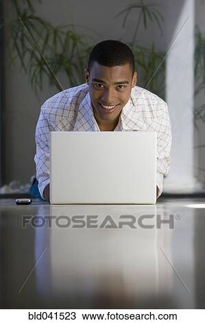 Stock Image - African man typing on laptop. Fotosearch
