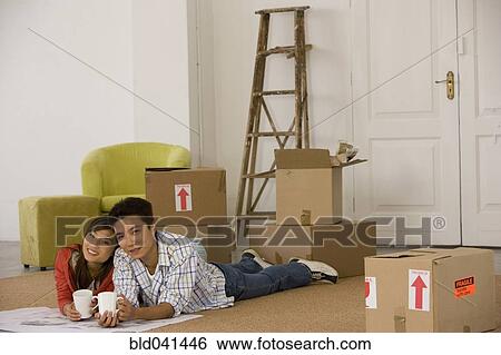 Asian couple on floor next to moving boxes View Large Photo Image Stock Photograph - Asian couple on floor next to moving boxes. Fotosearch