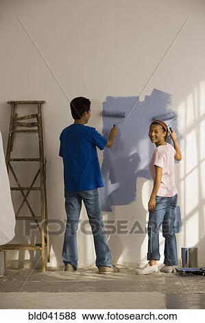 Stock Photo - Asian couple painting interior house. Fotosearch