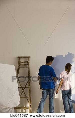 Stock Photo - Asian couple painting interior of house. Fotosearch