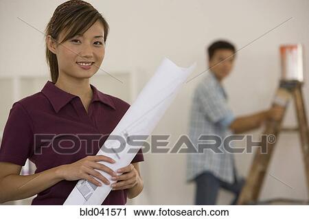 Stock Image - Asian couple renovating house. Fotosearch