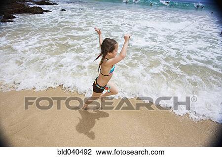 Stock Image - Asian girl running on beach. Fotosearch