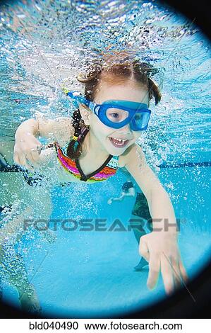 Stock Image - Asian girl swimming under water. Fotosearch