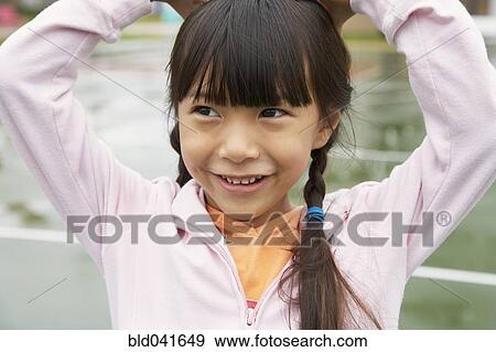 Stock Photo - Asian girl with hands on head. Fotosearch