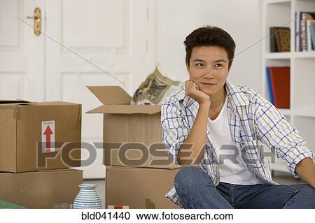 Asian man next to unpack moving boxes View Large Photo Image Stock Image - Asian man next to unpack moving boxes. Fotosearch
