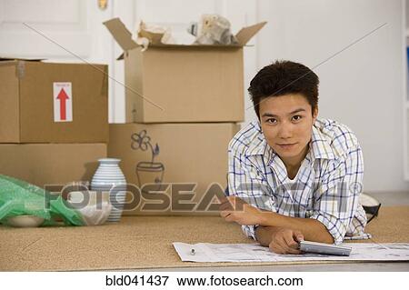 Asian man next to unpacked moving boxes View Large Photo Image Stock Photo - Asian man next to unpacked moving boxes. Fotosearch