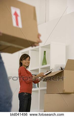 Asian woman packing moving boxes View Large Photo Image Stock Photograph - Asian woman packing moving boxes. Fotosearch