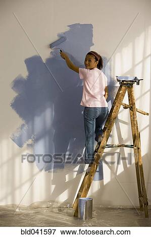 Stock Photo - Asian woman painting interior of house. Fotosearch