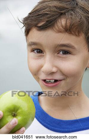 Stock Image - Boy holding apple. Fotosearch