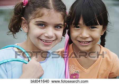 Stock Image - Close up of multi-ethnic girls smiling . Fotosearch