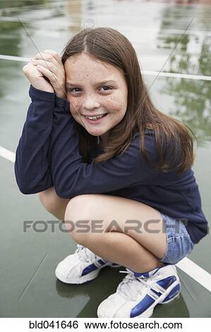 Stock Photograph - Girl crouching on playground. Fotosearch
