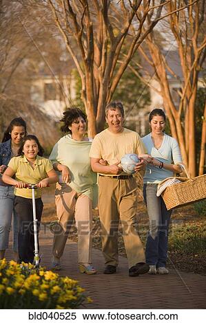 Stock Photography - Hispanic family walking in park. Fotosearch