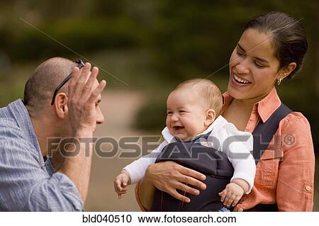 Stock Image - Hispanic family with baby in park. Fotosearch