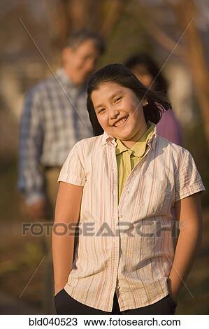 Stock Image - Hispanic girl with hands in pockets. Fotosearch
